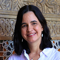 A profile photo of a woman with dark hair, dark eyes and olive skin.