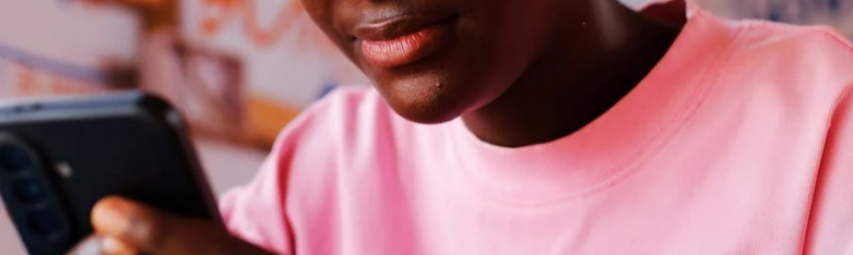 Young teenage girl from Ghana holding mobile phone smiling