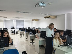 Clase con alumnos en estaciones de computadora.