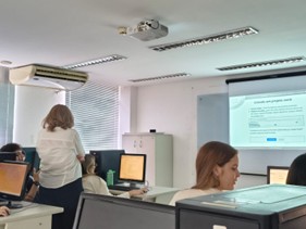 Clase con alumnos en estaciones de computadora.