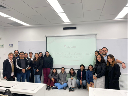 Participantes del taller. 15 personas a de lante de una pantalla.