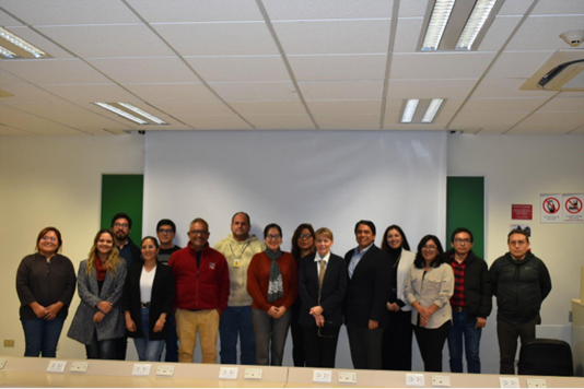 Participantes del taller. 15 personas a de lante de una pantalla blanca.