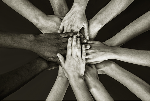 black and white image of multiple hands in centre